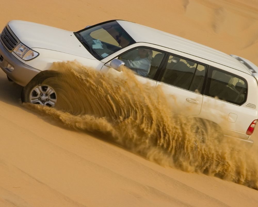 A man is driving in the desert